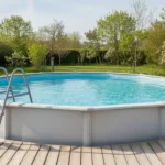 Piscine hors-sol tubulaire dans un jardin résidentiel au printemps, eau cristalline et terrasse en bois clair