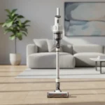 Aspirateur balai sans fil posé dans un salon moderne au parquet clair et lumineux
